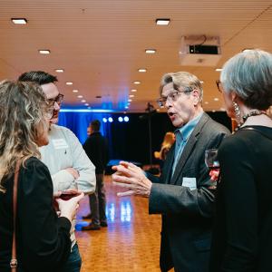 Two women and a man listen to another man talking in Krannert Center Lobby